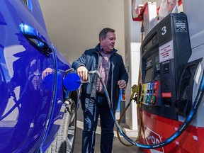 Premier Jason Kenney gases up his truck after a press conference at the Co-op on Macleod Trail S.E. on Friday, April 1, 2022. Alberta has temporarily cut 13 cents off the price of a litre of gasoline.