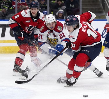 The Edmonton Oil Kings' Jake Neighbours (21) battles the Lethbridge Hurricanes' Noah Chadwick (8) and Kade Nolan (10) during first period WHL playoff action at Rogers Place in Edmonton, Saturday April 23, 2022.