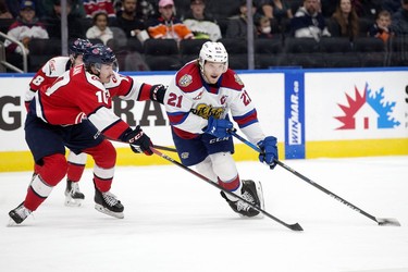 The Edmonton Oil Kings' Jake Neighbours (21) battles the Lethbridge Hurricanes' Kade Nolan (10) during first period WHL playoff action at Rogers Place in Edmonton, Saturday April 23, 2022.