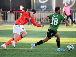 FC Edmonton's Tobias Warschewski (10) chases Cavalry FC's Bradley Vliet (18) during first half Canadian Premier League action at Clarke Stadium in Edmonton, on Friday, May 6, 2022. Photo by Ian Kucerak