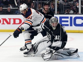 Evander Kane #91 of the Edmonton Oilers is bumped between Matt Roy #3 and Jonathan Quick #32 of the Los Angeles Kings during the first period in Game Three of the First Round of the 2022 Stanley Cup Playoffs at Crypto.com Arena on May 06, 2022 in Los Angeles, California.