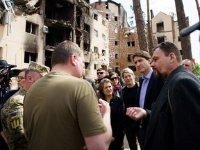 Prime Minister Justin Trudeau, Deputy Prime Minister Chrystia Freeland and Foreign Affairs Minister Melanie Joly speak with Irpin Mayor Oleksandr Markushyn as they visit a destroyed neighborhood in Irpin, Ukraine May 8, 2022.