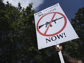 A gun control advocate holds a sign during a protest across from the National Rifle Association's Annual Meeting at the George R. Brown Convention Center in Houston, May 27, 2022.