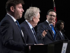Conservative leadership candidate Pierre Poilievre gestures towards Jean Charest as Roman Baber, left, Scott Aitchison and Leslyn Lewis, right, look on during a debate at the Canada Strong and Free Network conference, in Ottawa, Thursday, May 5, 2022.