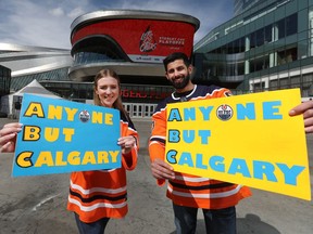 Allie Larson and Taylor Riar pose for a photo outside Rogers Place in Edmonton, on Monday, May 16, 2022. The couple travelled to Dallas last week to see a basketball game and the Stars and Flames play. They wore Oiler jerseys and had signs that said anyone but Calgary.