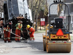 Road crews apply asphalt to a section of 85 Avenue near 112 Street, in Edmonton Wednesday May 11, 2022.