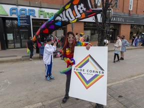 Claire Pearen sets up signs at Pride Corner on Friday, May 13, 2022 in Edmonton. After a year of sustained counter-protesting of religious extremism, the City of Edmonton recognizes the corner of 104 Street and Whyte Ave as Pride Corner.