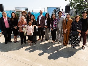 Members of the Chinatown community take a photo with Mike Saunders, senior vice president with Qualico Properties, during a ground breaking ceremony for the Station Lands development at EPCOR Tower in Edmonton, on Thursday, June 16, 2022.
