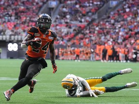 B.C. Lions running back James Butler (24) gets away from a tackle by the Edmonton Elks' Trey Hoskins and runs the ball in for his first touchdown of the game in Vancouver on Saturday, June 11, 2022.