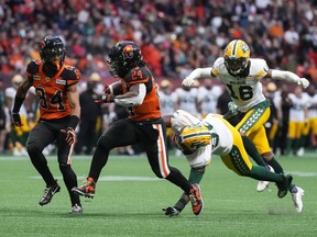 B.C. Lions defensive back T.J. Lee, right, intercepts a pass intended for Edmonton Elks receiver Jalin Marshall in Vancouver on Saturday, June 11, 2022.