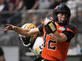 B.C. Lions quarterback Nathan Rourke (12) is pushed out of bounds by Edmonton Elks cornerback Jalen Collins in Vancouver on Saturday, June 11, 2022.