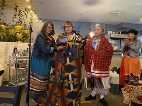 From left, Karen MacKenzie, Sheri Neapetung and elder Theresa Strawberry celebrate the proclamation of Okîsikow Way Day on June 14, 2022.
