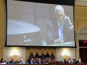 U.S. former Vice President Mike Pence speaks on his phone in an underground parking garage of the U.S. Capitol complex as he refuses to get into his motorcade and be evacuated from the Capitol on Jan. 6, 2021 in a video shown above, during the third of eight planned public hearings of the U.S. House Select Committee to investigate the January 6 Attack on the United States Capitol, on Capitol Hill in Washington, D.C., Thursday, June 16, 2022.