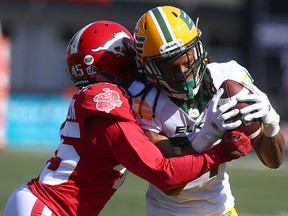 The Calgary Stampeders' Trumane Washington, left, tackles the Edmonton Elks' Derel Walker at McMahon Stadium in Calgary on June 25, 2022.