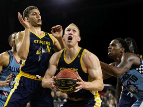 Edmonton Stingers' Brody Clarke (14) and Jordan Baker (8) battle Montreal Alliance's James Jean-Marie (14) for the ball during a Canadian Elite Basketball League game at Edmonton Expo Centre in Edmonton, on Wednesday, June 8, 2022.