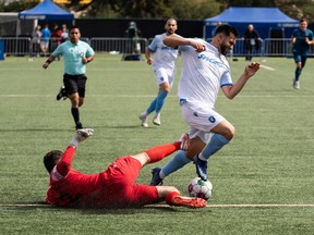 FC Edmonton's Gabriel Bitar (30) is stopped by York United FC's goalkeeper Gianluca Catalano (12) during first half Canadian Premier League action at Clarke Stadium in Edmonton, on Friday, July 1, 2022.