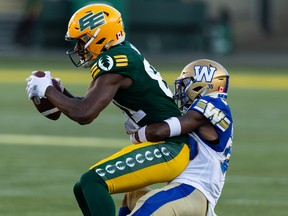 Edmonton Elks' Hakeem Butler (81) is tackled by Winnipeg Blue Bombers' Demerio Houston (35) during first half CFL football action at Commonwealth Stadium in Edmonton on Friday, July 22, 2022.