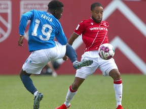Edmonton Tboy Fayia flicks the ball past Cavalry Bradley Vliet during CPL soccer action between Cavalry FC and FC Edmonton at ATCO Field at Spruce Meadows in Calgary on Saturday, July 30, 2022. Jim Wells/Postmedia
