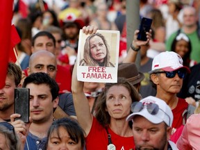 A woman holds a photo of Tamara Lich, one of the main fundraisers and organizers and part of the protests by truckers opposing coronavirus disease (COVID-19), across from Parliament Hill, as a protest against COVID-19 mandates takes place on Canada Day, in Ottawa, Ontario, Canada July 1, 2022.