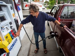 A man gasses up his truck at a gas station.