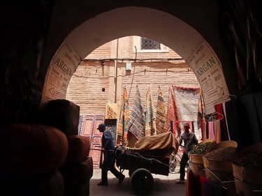 A man pulls a wagon through the narrow streets of the medina in Marrakech.