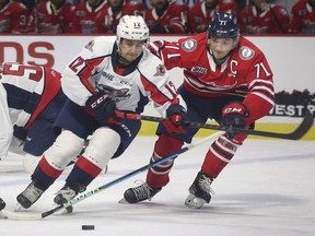 Ryan Abraham, left, of the Windsor Spitfires and Ty Tullio of the Oshawa Generals battle for the puck during a pre-season game on Oct. 3, 2021, at the WFCU Centre in Windsor, Ont.