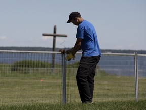 Taser Muir sets up fencing as crews continue to prepare the Lac Ste. Anne pilgrimage site ahead of a visit by Pope Francis, near Alberta Beach Wednesday July 20, 2022.