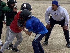 Former Edmonton Elks defensive tackle Eddie Steele works with youngsters at a football camp in Cambridge Bay, Nunavut, on Tuesday, July 19, 2022.