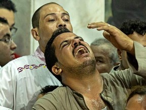 Egyptian mourners react during the funeral of victims killed in Cairo Coptic church fire, at the church of the Blessed Virgin Mary in the Giza Governorate on Aug. 14, 2022.