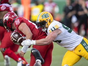 Calgary Stampeders quarterback Tommy Stevens (15) is sacked by Edmonton Elks defensive tackle Jake Ceresna (94) in Edmonton on June 3, 2022.