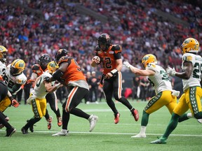 B.C. Lions quarterback Nathan Rourke (12) runs the ball for a touchdown past Edmonton Elks linebacker Adam Konar in Vancouver on June 11, 2022.
