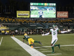 Saskatchewan Roughriders defensive back Nick Marshall (3) reacts as Edmonton Elks quarterback Taylor Cornelius (15) scores a touchdown in Edmonton on August 13, 2022.