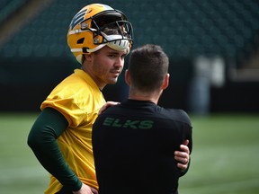 Quarterback Mike Beaudry (14) speaks with then-teammate Nick Arbuckle during the first day of Edmonton Elks rookie camp at Commonwealth Stadium in Edmonton on May 11, 2022.