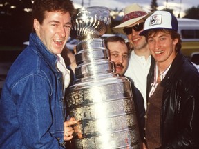 Edmonton Oilers Kevin Lowe, left, equipment manager Lyle 'Sparky' Kulchisky, Mark Messier and Wayne Gretzky hold the Stanley Cup after leaving David's Restaurant in Edmonton May 21, 1984.  The Oilers won their first Stanley Cup on May 19, 1984.