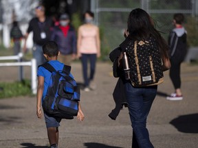 Parents and students walk to toward school for the first day of classes in 2021 in Edmonton.