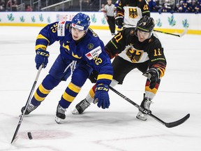 Sweden's Liam Ohgren (25) and Germany's Korbinian Geibel (11) battle for the puck during third period IIHF World Junior Hockey Championship action in Edmonton on Monday August 15, 2022.