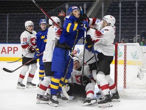 Sweden's Simon Edvinsson (7) and Switzerland's Attilio Biasca (17) rough it up during second period of IIHF World Junior Hockey Championship action in Edmonton on Wednesday, Aug. 10, 2022.