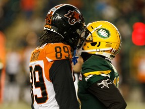 Former Edmonton Elks defensive back Tyquwan Glass (19) shares words with former B.C. Lions receiver Duron Carter (89) during Edmonton's last home win at Commonwealth Stadium on Oct. 12, 2019.