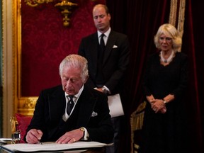 Britain's Prince William, Prince of Wales (centre) and Britain's Camilla, Queen Consort (right) watch as Britain's King Charles III signs an oath to uphold the security of the Church in Scotland, during a meeting of the Accession Council inside St James's Palace in London, Saturday, Sept. 10, 2022, to proclaim him as the new King.