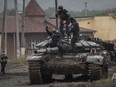 Police officers take a selfie on a destroyed Russian tank in the town of Izium, recently liberated by Ukrainian Armed Forces, in Kharkiv region, Ukraine September 14, 2022.