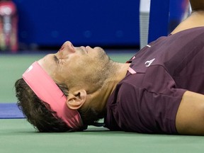 Spain's Rafael Nadal lies on the court and seeks medical attention after hitting himself in the face with his racket during his 2022 US Open Tennis tournament men's singles second round match against Italy's Fabio Fognini at the USTA Billie Jean King National Tennis Center in New York, on September 1, 2022.