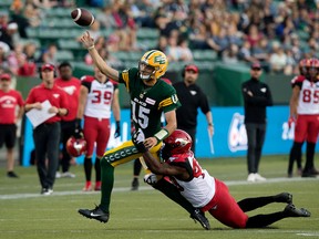 The Edmonton Elks' quarterback Taylor Cornelius (15) is tackled by the Calgary Stampeders' Shawn Lemon (40) during first half CFL action at Commonwealth Stadium in Edmonton, Saturday Sept. 10, 2022. Photo By David Bloom