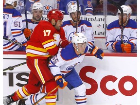 Calgary Flames' Milan Lucic battles Edmonton Oilers Dylan Holloway in first period NHL preseason action at the Scotiabank Saddledome in Calgary on Wednesday, Sept. 28, 2022.