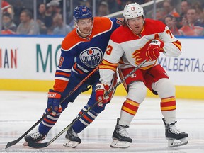 Oilers forward Zach Hyman (18) and Calgary Flames forward Tyler Toffoli (73) battle for position during the first period at Rogers Place, Friday, Sept. 30, 2022.