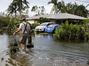A resident walks back home on a flooded street following Hurricane Ian in Fort Myers, Fla., Thursday, Sept. 29, 2022.