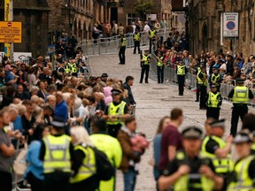 Police officers control the crowds on Castlehill in Edinburgh, Scotland, Sunday, Sept. 11, 2022, as preparations are made for the arrival of the coffin of Queen Elizabeth II.