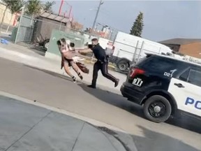 Screenshot of a video depicting an Edmonton police officer seen shoving a woman to the ground during an arrest on Thursday, Sept. 15, 2022, in the area of 106 Avenue and 101 Street. Police later released footage showing the woman was brandishing a knife.