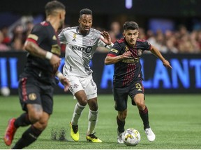 Sep 10, 2022; Atlanta, Georgia, USA; Atlanta United midfielder Thiago Almada (right) controls the ball against Toronto FC midfielder Mark-Anthony Kaye (middle) in the second half at Mercedes-Benz Stadium.