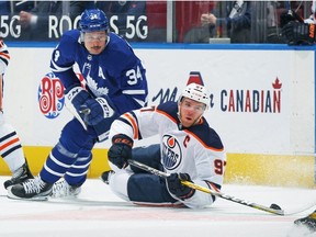 Connor McDavid #97 of the Edmonton Oilers battles for the puck against Auston Matthews #34 of the Toronto Maple Leafs during the first period an NHL game at Scotiabank Arena on March 29, 2021 in Toronto, Ontario, Canada.