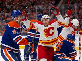 Andrew Mangiapane, right, of the Calgary Flames celebrates a goal against the Edmonton Oilers during the first period at Rogers Place on Saturday, Oct. 15, 2022.